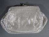 an image of a white beaded purse sitting on top of a table