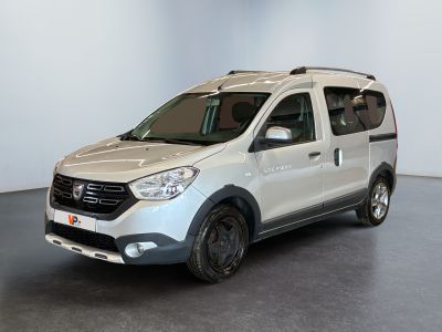 La camionnette blanche est garée dans une grande pièce au sol noir
