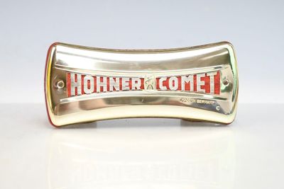 une poignée argentée et rouge portant l'inscription « Hohner Comet »