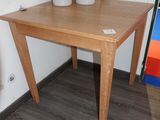 une table en bois sur laquelle sont posés deux pots de fleurs