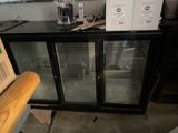 a refrigerator with a glass door and a box on top of it