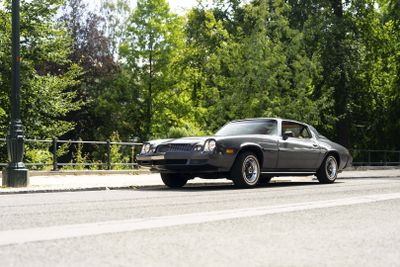a black car that is driving down the street