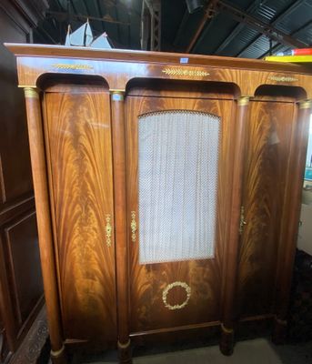 une vieille armoire en bois munie d'une porte vitrée