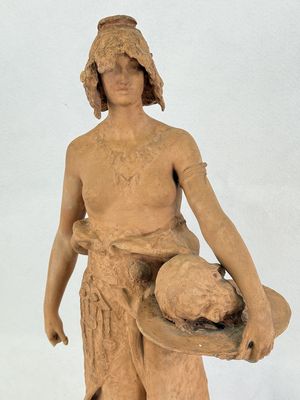 une statue représentant un homme tenant un chapeau et un bol