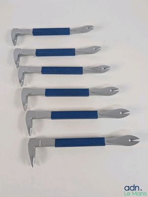 six outils bleus et argentés sont alignés sur une surface blanche
