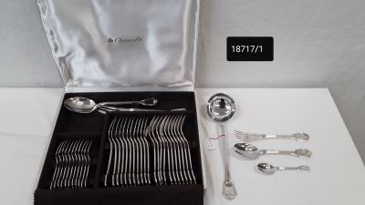 a box of silverware on a table with a silver spoon and fork