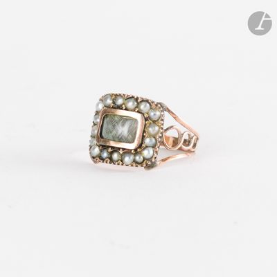un gros plan d'une bague ornée de perles sur fond blanc