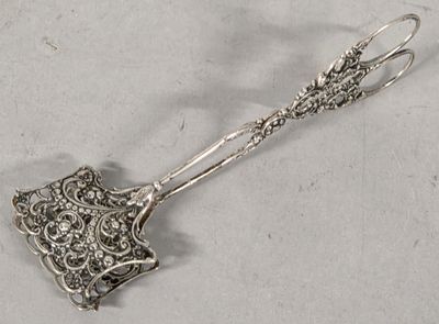 a silver spoon with a handle on a white surface
