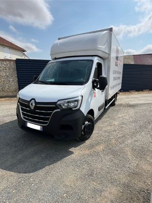 la camionnette blanche est garée sur le parking à côté d'un bâtiment
