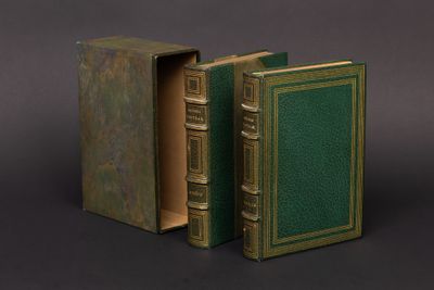 un vieux livre à la couverture verte, ouvert sur une surface noire