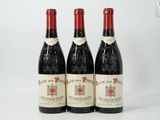 three bottles of red wine sitting next to each other on a white surface