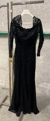 black dress on a hanger in front of a white wall