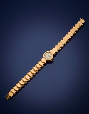 a gold wrist watch with a white dial on a blue background