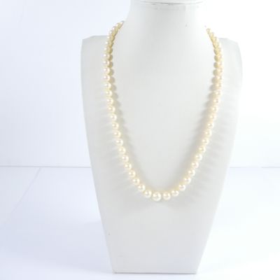 a close up of a necklace on a mannequin with a white background
