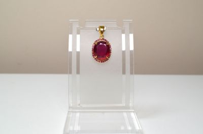 Un pendentif en argent vermeil, serti d'un rubis facetté ova…