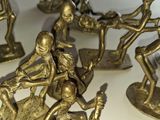 figurines en laiton représentant un groupe de personnes sur une surface blanche