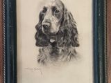 portrait of a cocker dog in a black frame on a wooden wall