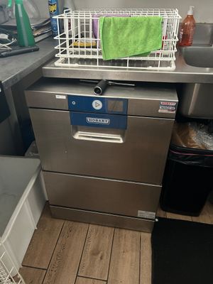 un lave-vaisselle dans la cuisine, sur lequel est posée une serviette verte