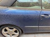 a blue car that is parked on the side of the street