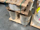 several buckets of paint are stacked on pallets in a warehouse
