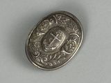 an image of a silver button with a crown on it