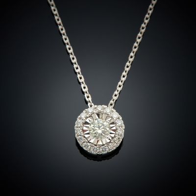 un pendentif en or blanc et diamants sur une chaîne