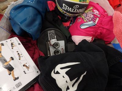 un tas de vêtements et un casque posés sur un lit