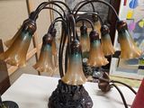 une table sur laquelle se trouve une lampe et un bouquet de fleurs