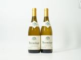 deux bouteilles de vin blanc posées l'une à côté de l'autre sur une table