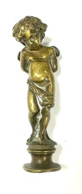 brass figurine of a boy holding a bird on a pedestal