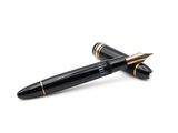 un gros plan d'un stylo orné de finitions noires et dorées