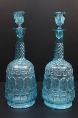 deux vases en verre bleu posés sur une table noire
