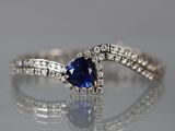 un gros plan sur une bague de fiançailles sertie d'un saphir bleu et de diamants