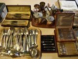 a lot of silver spoons and silverware on a table