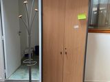 un porte-manteau dans un coin de la pièce, près d'une porte