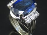 gros plan d'une bague en saphir bleu et diamant sur une surface noire