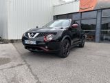La Nissan Juke noire est garée devant un immeuble.