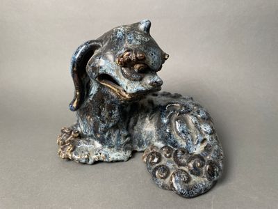 a statue of a dog that is sitting on the ground