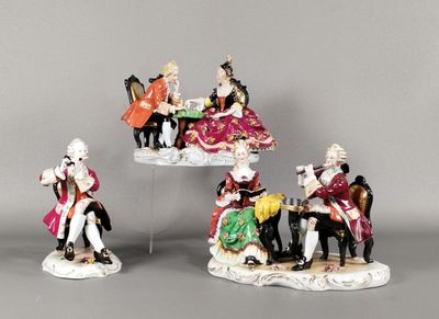 quatre figurines représentant des personnes vêtues de tenues élégantes, assises sur une table