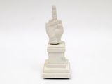 a white statue of a hand with a finger on it