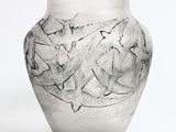 un vase en verre avec un motif sur une surface blanche