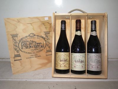 trois bouteilles de vin se trouvent dans une caisse en bois posée sur un comptoir