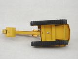 a yellow toy truck with black wheels on a white surface