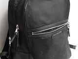sac à dos en cuir noir sur fond blanc, muni de fermetures éclair et de fermetures éclair