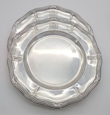 a silver plate on a white table with a crown on it