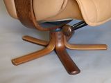 a brown leather chair with a wooden base and a black seat