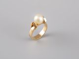a gold ring with a pearl and a diamond