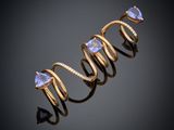 gros plan d'une bague en or avec une pierre violette