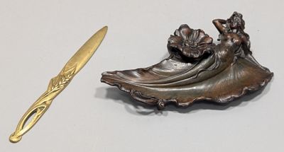 bronze figurine of a woman with a fan and a gold spoon