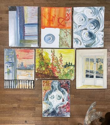 de nombreux tableaux accrochés au mur d'une pièce